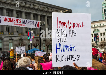 San Francisco, USA. 19. Jan 2019. Teilnehmer bis März der Damen hält 'eingewanderten Rechte sind Menschenrechte" zu unterzeichnen; die Rallye Bühne und dem Rathaus Gebäude im Hintergrund sichtbar Stockfoto