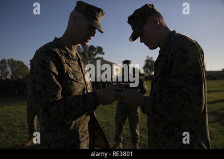 Us Marine Corps Erster Sergeant Frank B. Kammer, Links, und PFC-Cory C. Neimeister, sowohl zu speziellen Zweck Marine Air Ground Task Force-Crisis Response-Africa, tauschen Sie das erste Stück Kuchen während einer Zeremonie in der Feier des U.S. Marine Corps' 241 in Morón, Spanien, 10. November 2016 statt. Während des Marine Corps geburtstag Zeremonie, die Älteste und jüngste Marines vorhanden traditionell Exchange das erste Stück Kuchen, was bedeutet, dass die Weitergabe von Wissen für Generationen von Marines zu kommen. Us-Marines und Matrosen zu speziellen Zweck Marine Air-Ground Task Force zugeteilt. Stockfoto