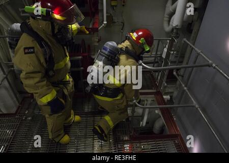 Karibik (Nov. 14, 2016) Segler auf USS Zumwalt (DDG 1000) bewegen Sie sich durch die wichtigsten Maschinen Zimmer ein, um den Standort eines Feuer während eines General Quarters Übung zugewiesen. Mit Crew von 147 Segler, Zumwalt ist das Typschiff einer Klasse von Zerstörern der nächsten Generation konzipiert Seemacht, indem Sie kritische Missionen und die Verbesserung der US-Abschreckung, die Projektion und das Meer steuern Ziele zu stärken. Stockfoto