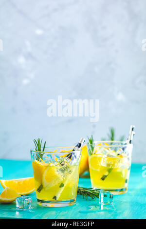 Zitrone Alkohol Cocktail mit Eis, Zitrone und Rosmarin Kräuter auf einem blau türkis Holztisch Hintergrund Oberfläche. Traditionelle italienische hausgemachte Zitrone Stockfoto