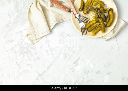 Eingelegte Gurken oder Gurken in der Platte auf hellgrau Betonoberfläche Tabelle von oben. Platz kopieren, Ansicht von oben, freier Platz für Ihren Text. Stockfoto