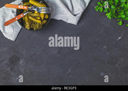 Eingelegte Gurken oder Gurken in Schale auf der Rückseite Betonoberfläche Tabelle von oben. Platz kopieren, Ansicht von oben, freier Platz für Ihren Text. Stockfoto
