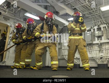 SOUTH CHINA SEA (Nov. 14, 2016) Segler auf die Amphibisches Schiff USS Makin Island (LHD 8) einen simulierten Brand bekämpfen bei einer Beschädigung des Bohrers zugeordnet. Makin Island, das Flaggschiff der Makin Island Amphibious Ready-Gruppe, die in den USA 7 Flotte Fläche von Operationen mit dem begonnen 11 Marine Expeditionary Unit zur Unterstützung der Sicherheit und Stabilität in der Indo-Asia-Pazifik-Region. Stockfoto