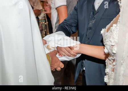 Traditionelle Hochzeit handfasting in der orthodoxen Kirche. Die Hände der Braut und des Bräutigams sind mit einer Hochzeit bestickt Handtuch gebunden. Stockfoto