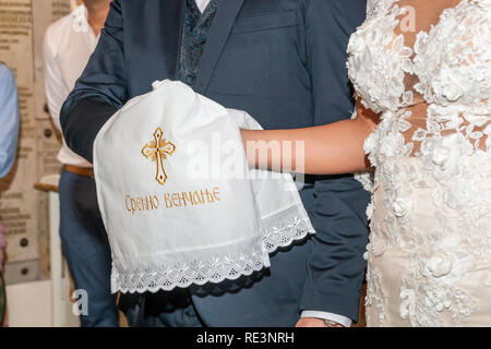 Traditionelle Hochzeit handfasting in der orthodoxen Kirche. Die Hände der Braut und des Bräutigams sind mit einer Hochzeit bestickt Handtuch gebunden. Inschrift "Срећно венчањ Stockfoto