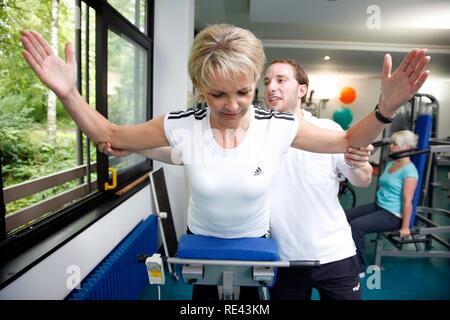 Patienten, die in den Muskeln Training auf verschiedenen Maschinen im Unterrichtsraum, Physiotherapie in der neurologischen Stockfoto