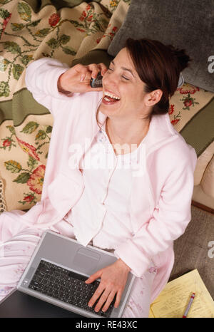 Junge Frau arbeiten im Home Office im Schlafanzug, USA Stockfoto