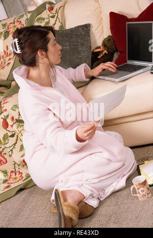 Junge Frau arbeiten im Home Office im Schlafanzug, USA Stockfoto