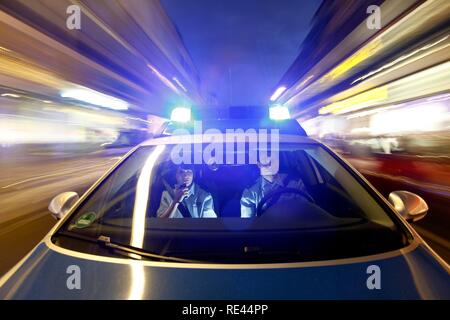 Polizei Streifenwagen fahren mit Blaulicht und Sirenen Stockfoto