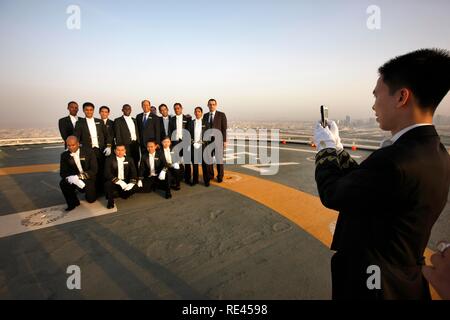 Butlers auf dem Hubschrauberlandeplatz gesäumt sind auf dem Dach des Burj Al Arab, Luxushotel ein VIP-Gast zu empfangen, Dubai Stockfoto