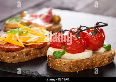 Mini Sandwiches essen. Brushetta oder authentische traditionelle spanische Tapas zum Mittag- Tabelle. Leckere Snacks, Vorspeisen, Antipasti auf Party oder Picknick t Stockfoto