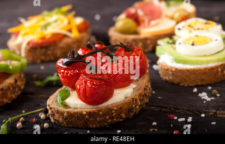 Mini Sandwiches essen. Brushetta oder authentische traditionelle spanische Tapas zum Mittag- Tabelle. Leckere Snacks, Vorspeisen, Antipasti auf Party oder Picknick t Stockfoto