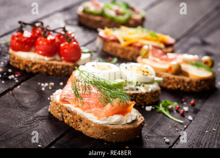 Mini Sandwiches essen. Brushetta oder authentische traditionelle spanische Tapas zum Mittag- Tabelle. Leckere Snacks, Vorspeisen, Antipasti auf Party oder Picknick t Stockfoto
