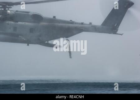 Am Meer, im Indischen Ozean (28. November 2016) eine Maritime Raid Force Marine springt von einer CH-53E Super Stallion während einer helocast Ausbildung Evolution in der Nähe der USS Makin Island (LHD 8) flott in den Indischen Ozean, Nov. 28, 2016. Helocasting ermöglicht Aufklärung Teams längere Strecken, bevor Sie zu Ihrer endgültigen Aufstieg zu einer objektiven Bereich fallen zu reisen. Die Marine ist mit dem Befehl Element und das Flugzeug und die Crew sind mit Marine Medium Tiltrotor Squadron 163 (verstärkt), 11 Marine Expeditionary Unit. Stockfoto