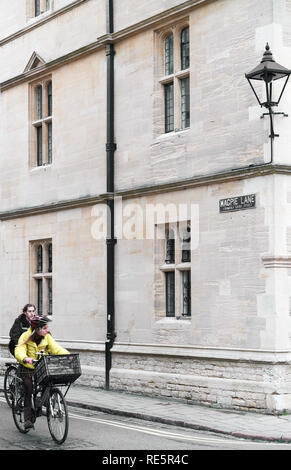 Zwei Studenten auf ihre Fahrräder, eine Frau, die anderen männlichen, an der Ecke der Magpie Lane, neben dem Jackson Gebäude von Corpus Christi co Stockfoto