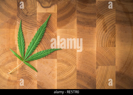 Makro Fotos von Marihuana pflanze Blatt auf Holz- Hintergrund. Die cannabispflanze Nähe zu sehen. Anlage von Marihuana für medizinische Zwecke mit einem hohen Anteil an CBD Stockfoto