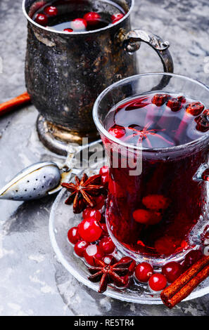Winter heißen Tee mit Beeren und Gewürzen in Glas Schale Stockfoto