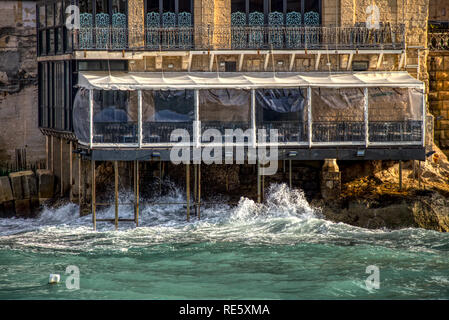 Ein Restaurant auf der Insel Malta, die von Säulen über dem Meer unterstützt wird von den Wellen zerschlagen Stockfoto