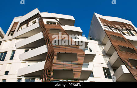 Moderne kantiges Design high-rise apartment Blocks von unten angezeigt Außenverkleidung vor blauem Himmel gesehen Stockfoto