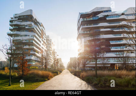 Sonnenaufgang über eine elegante moderne Apartmentkomplex auf der Suche einen Fußgängerweg in die Glut der Sonne Stockfoto