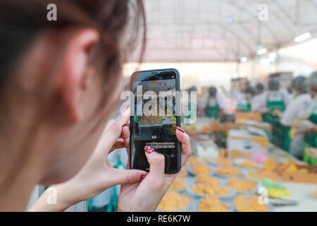 Bangkok, Thailand. Jan, 2019 20. Ein Tourist nimmt Fotos der Mango klebriger Reis in Bangkok, Thailand, Jan. 20, 2019. Der Reis war der 1.500-kg Klebreis, 2.300 - 5.000 kg Cocossaft und Mangos. Das Gesamtgewicht der Mango klebriger Reis 4.500 Kilogramm erreicht. Die Veranstaltung zielt darauf ab, einen Guinness Weltrekord für die größte Portion mango klebriger Reis zu setzen. Credit: Zhang Keren/Xinhua/Alamy leben Nachrichten Stockfoto