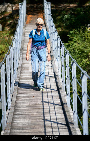 Senioren gehen auf eine Hängebrücke über den Fluss Soca, in der Nähe von Kobarid, Primorska, Slowenien. Stockfoto