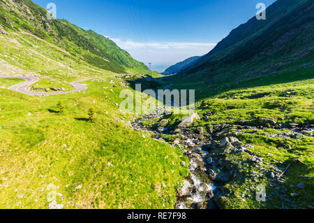 Balea stream Fagaras Bergen. Wunderbare Serpentine von transfagarasan Straße auf der linken Seite. schönen Sommer Landschaft. Stromleitungen entlang des Valle Stockfoto