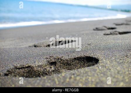 Spuren im schwarzen Sand La Reunion Insel Stockfoto