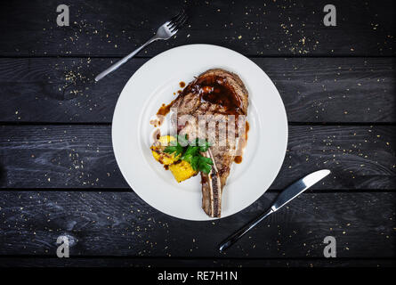 Rib Eye Steak mit Mais auf dem weißen Teller serviert. Stockfoto