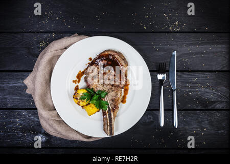 Rib Eye Steak mit Mais. Auf dem hölzernen Hintergrund. Ansicht von oben. Stockfoto
