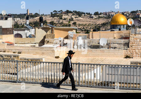 Orthodoxen jüdischen Mann zu Fuß auf den Dächern Jerusalems, mit Tempelberg im Hintergrund Stockfoto