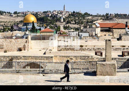 Orthodoxen jüdischen Mann zu Fuß auf den Dächern Jerusalems, mit Tempelberg im Hintergrund Stockfoto