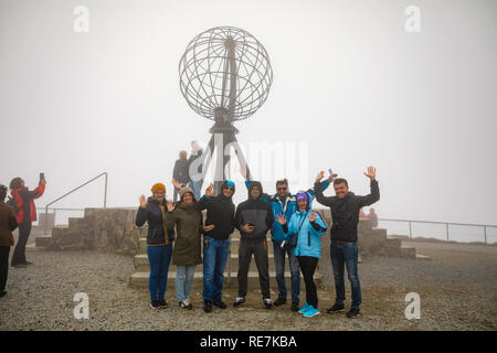 Nordkap, Norwegen - 26.06.2018: Gruppe von Touristen kommen zu den berühmten nordkap und liebe Fotos mit den ikonischen Globus Skulptur zu nehmen, auch auf einem sehr nebligen Tag mit schlechter Sicht, Norwegen Stockfoto