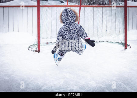 Kind Kleinkind fallen lernen Eislaufen am Eislaufplatz die Überwindung der Schwierigkeiten, durch Verletzungen in der Snow Park im Winter Urlaub Stockfoto