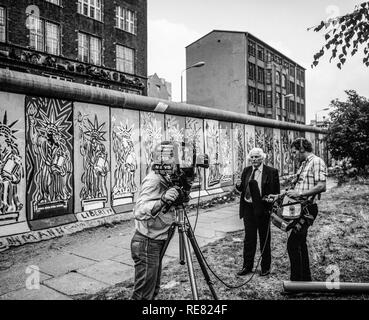 Am 1986. August führte das CBS-Fernsehteam ein Interview vor der mit Fresken der Freiheitsstatue geschmückten Berliner Mauer, West-Berliner Seite, Deutschland, Europa, Stockfoto