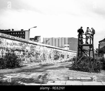 August 1986, Berliner Mauer Graffitis, Menschen auf der Aussichtsplattform über der Wand suchen, Zimmerstraße Street, West Berlin, Deutschland, Europa, Stockfoto