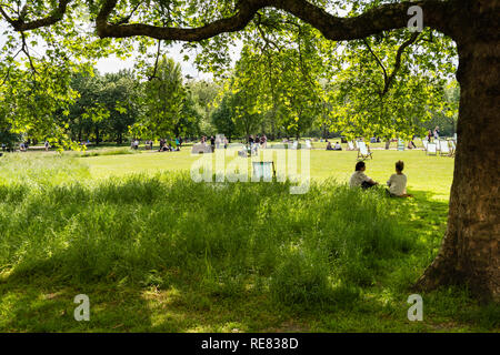 Junges Paar entspannende im Green Park, London an einem Sommertag. Stockfoto