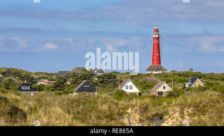 Rote Leuchtturm zwischen den Häusern des Dorfes von Schiermonnikoog Stockfoto