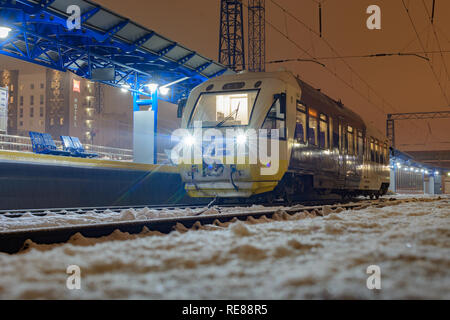 Kiew, Ukraine - Dezember 14, 2018: Schiene bus PESA 620M Reise von Kiew zu Flughafen Boryspil. An der Kiev Personenbahnhof auf der Plattform in der Nacht. Stockfoto