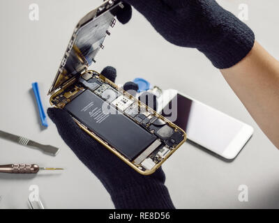 Techniker oder Ingenieur Öffnung gebrochen Smartphone zur Reparatur oder ersetzen Sie das neue Teil auf Schreibtisch Stockfoto