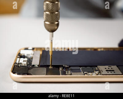 Techniker oder Ingenieur zerlegen Komponenten aufgeschlüsselt Smartphone für die Reparatur oder den neuen Teil auf dem Schreibtisch ersetzen Stockfoto