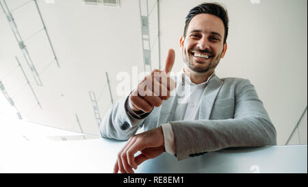 Happy business Mann zeigt Daumen anmelden Geste. Stockfoto
