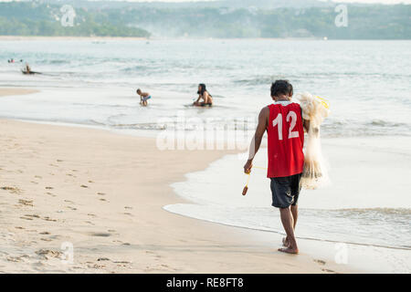 Balinesische fisherman Spaziergänge am Jimbaran Strand. Der Strand hat Fischrestaurants und Jimbaran Fischmarkt ist das größte seiner Art in Bali. Stockfoto