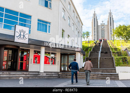 Akureyri, Island - 17. Juni 2018: Stadtbild Straßenbild Straße in der Stadt Dorf Stadt mit zwei Leuten auf Schritte zur berühmten Kirche auf einem Hügel und Hotel Kea Stockfoto