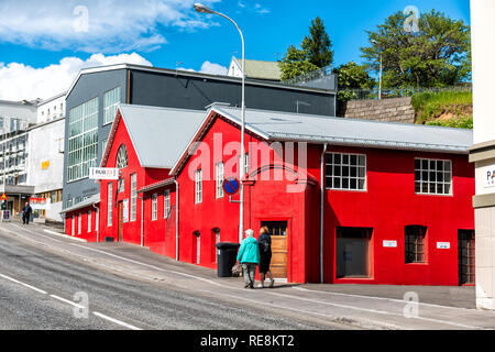 Akureyri, Island - 17. Juni 2018: Straße Straße in der Stadt Dorf Stadt mit bunten lebendigen Rot lackiert House Restaurant und Menschen zu Fuß auf dem Bürgersteig Stockfoto