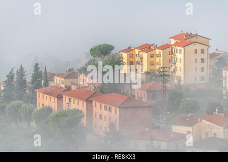 Chiusi Scalo Nebel Nebel Sonnenaufgang auf dem Dach Häuser Gebäude in Umbrien, Italien nahe der Toskana mit weichen Wolken, Dunst, die bedeckt Stadt Stadtbild skyli Stockfoto