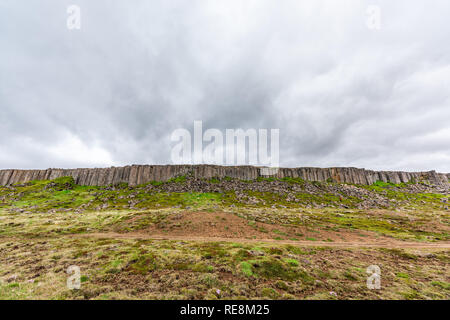 Gerduberg Basaltsäulen Weitwinkel Landschaft in Snaefellsnes Island mit grünem Gras im Sommer Tag, stürmische Wolken und niemand Stockfoto
