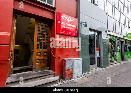 Reykjavik, Island - 19. Juni 2018: Straße Straße Bürgersteig in der Innenstadt von Center und Zeichen für Post mit farbenfrohen roten Gebäude Eingang und nobo Stockfoto