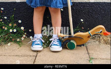 Geringe Aufnahme von Mädchen in Sneakers mit Schiebe ente Spielzeug Stockfoto