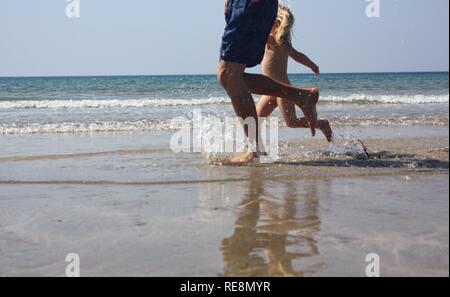 Vater Tochter durch das Meer läuft Stockfoto